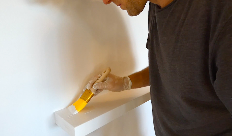 Cutting in the final coat of paint on the diy floating shelves